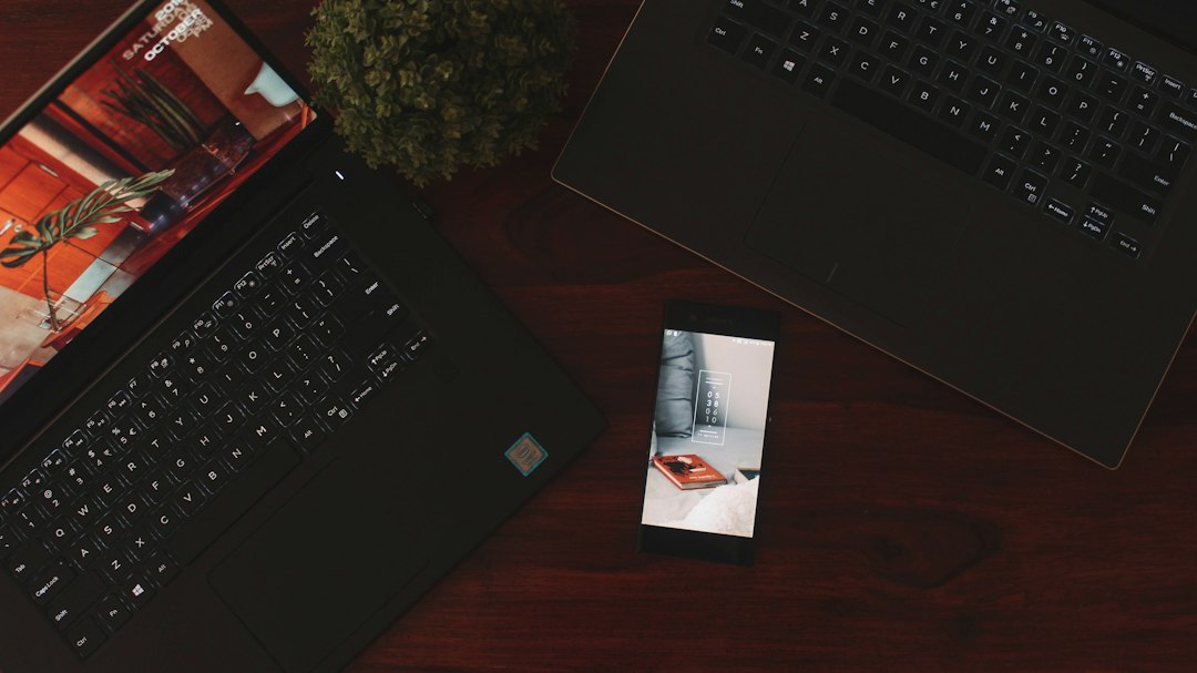 Réseaux sociaux et site web : smartphone à côté de deux ordinateurs portables